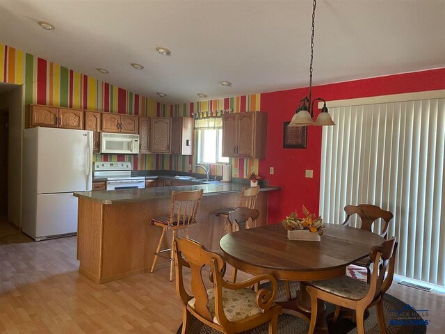 dining room featuring sink and light hardwood / wood-style flooring