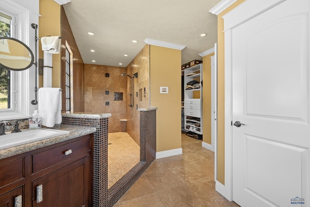 bathroom featuring vanity, tile patterned floors, a wealth of natural light, and tiled shower