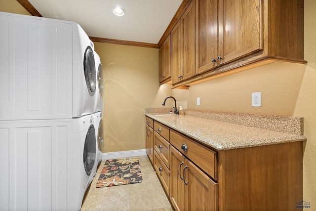 washroom featuring cabinets, light tile patterned floors, sink, crown molding, and stacked washer / dryer