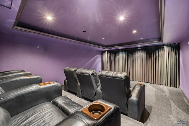 home theater room with carpet floors and a tray ceiling