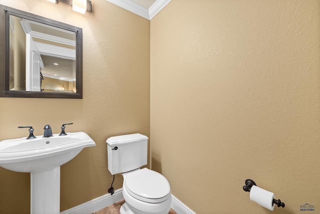 bathroom with ornamental molding, sink, and toilet