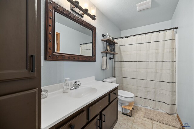 bathroom with a textured ceiling, toilet, vanity, a shower with shower curtain, and tile patterned flooring