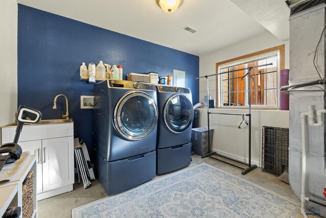 laundry room featuring cabinets, independent washer and dryer, and sink