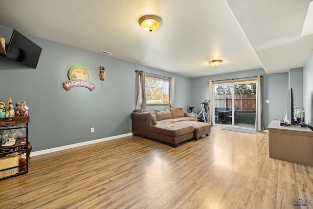 living room with light hardwood / wood-style flooring and a textured ceiling