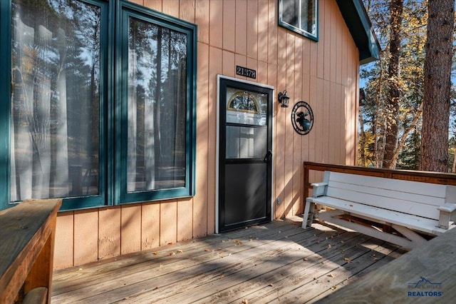 view of exterior entry featuring a wooden deck