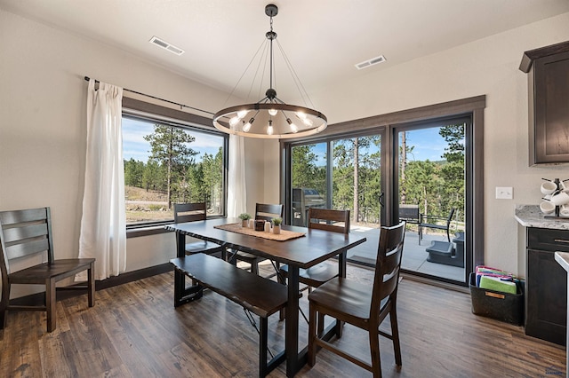 dining space featuring a wealth of natural light, a chandelier, and dark hardwood / wood-style floors