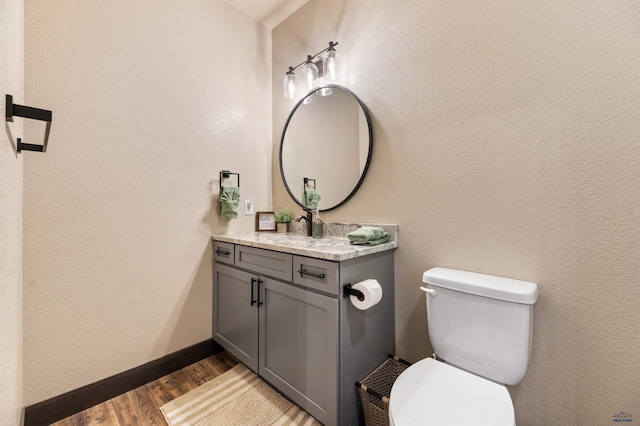 bathroom featuring toilet, hardwood / wood-style floors, and vanity