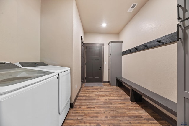 clothes washing area featuring dark wood-type flooring and separate washer and dryer