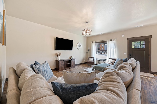 living room featuring hardwood / wood-style flooring and an inviting chandelier