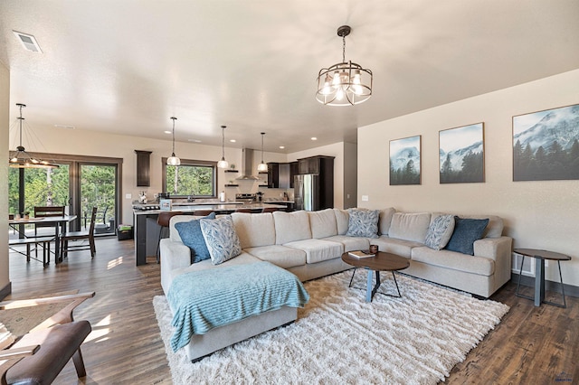 living room featuring an inviting chandelier and dark hardwood / wood-style floors