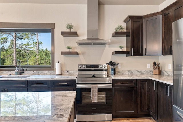 kitchen featuring light stone counters, appliances with stainless steel finishes, sink, and ventilation hood