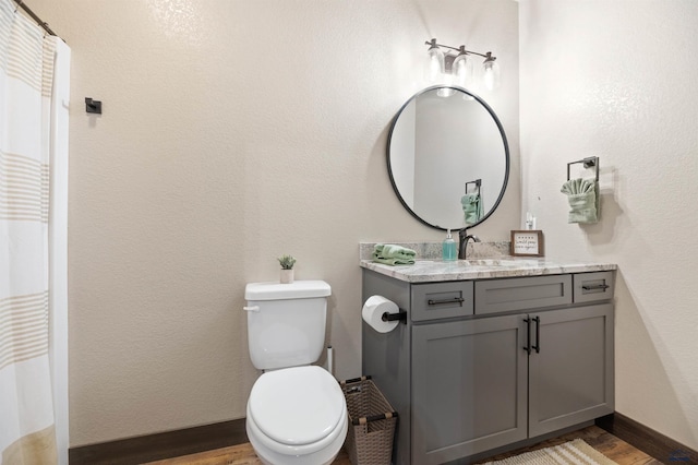 bathroom with vanity, toilet, and hardwood / wood-style floors