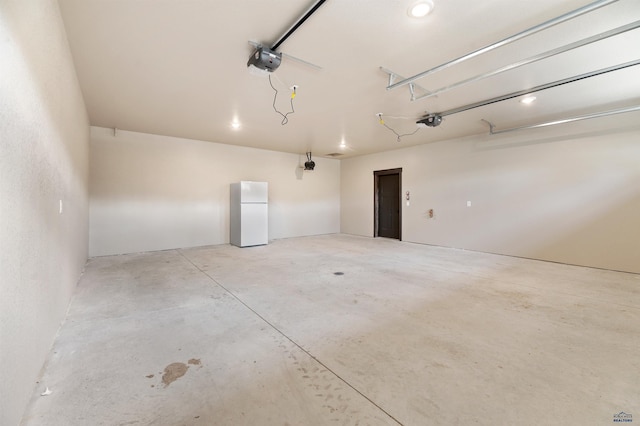 garage featuring a garage door opener and white refrigerator