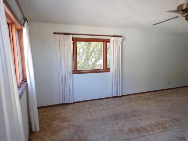 carpeted spare room with ceiling fan