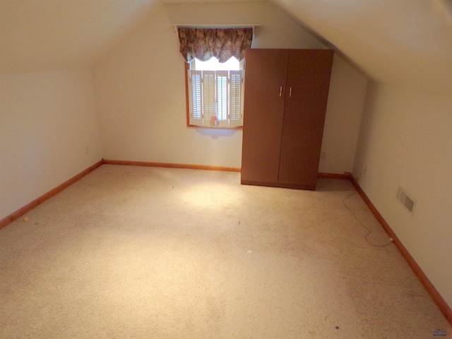 additional living space with lofted ceiling and light carpet