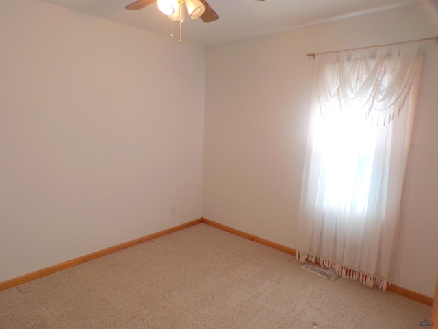 carpeted spare room with ceiling fan