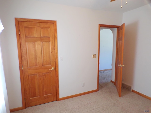 unfurnished bedroom with light colored carpet and ceiling fan