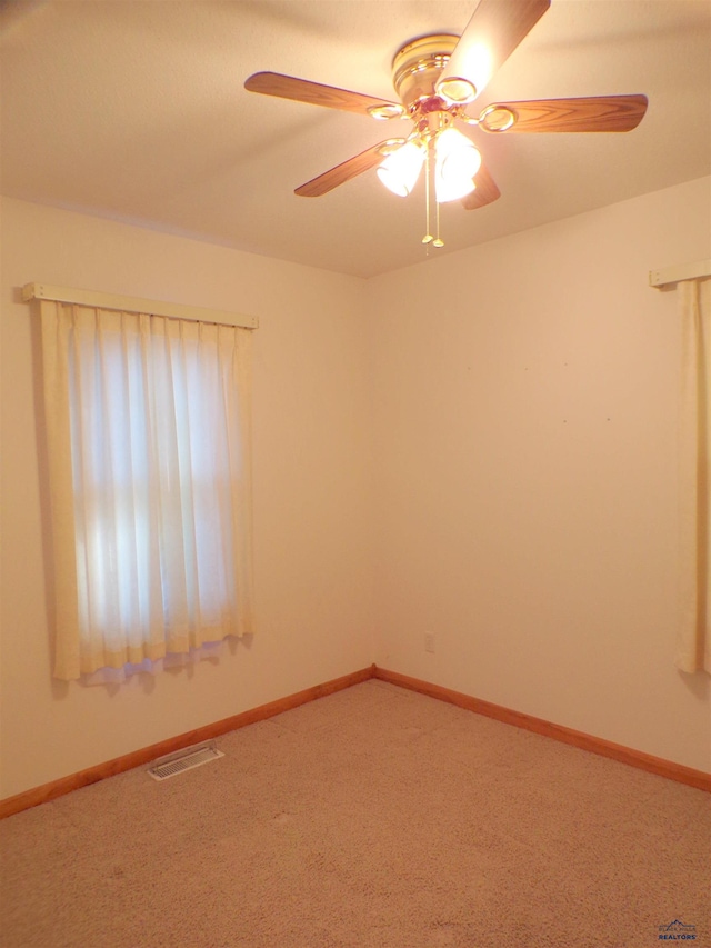 spare room with ceiling fan and carpet