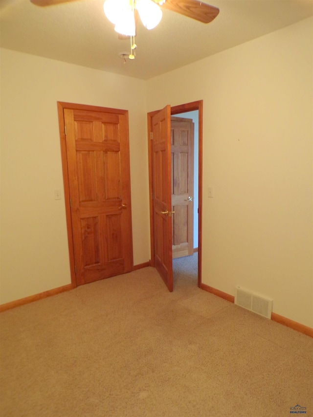 unfurnished bedroom featuring light carpet and ceiling fan