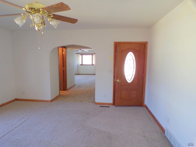 carpeted foyer featuring ceiling fan