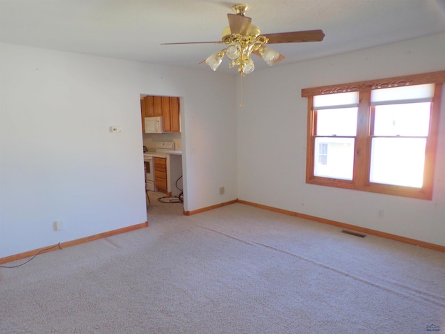 empty room featuring light colored carpet and ceiling fan