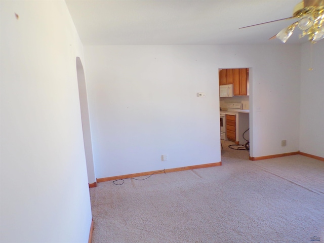 415 Spark St, Lead, SD 57754 - empty room featuring a ceiling fan, arched walkways, light colored carpet, and baseboards