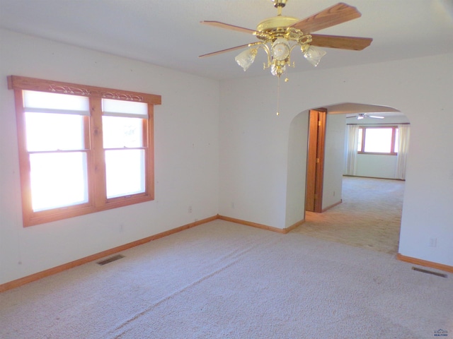 carpeted spare room featuring ceiling fan