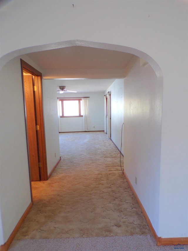 hallway featuring light colored carpet