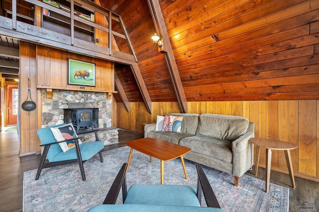 living room featuring a wood stove, wood walls, lofted ceiling with beams, and hardwood / wood-style floors