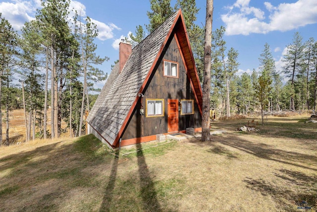 rear view of house featuring a yard