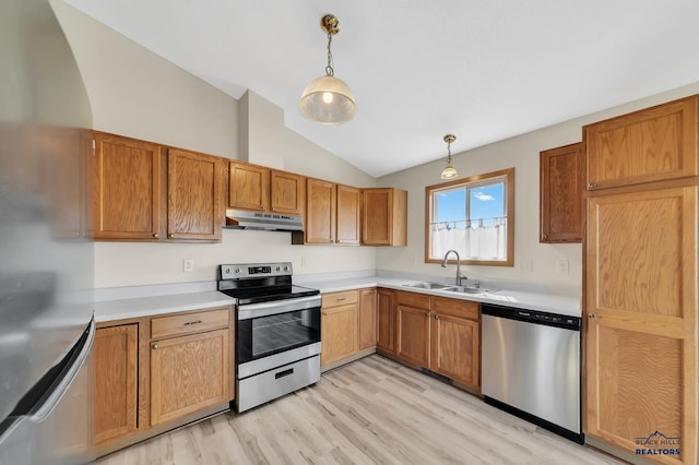 kitchen featuring lofted ceiling, hanging light fixtures, sink, light wood-type flooring, and appliances with stainless steel finishes