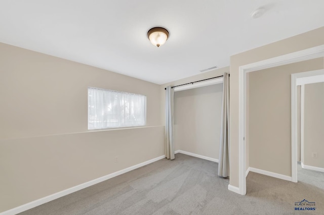 unfurnished bedroom featuring a closet and light carpet