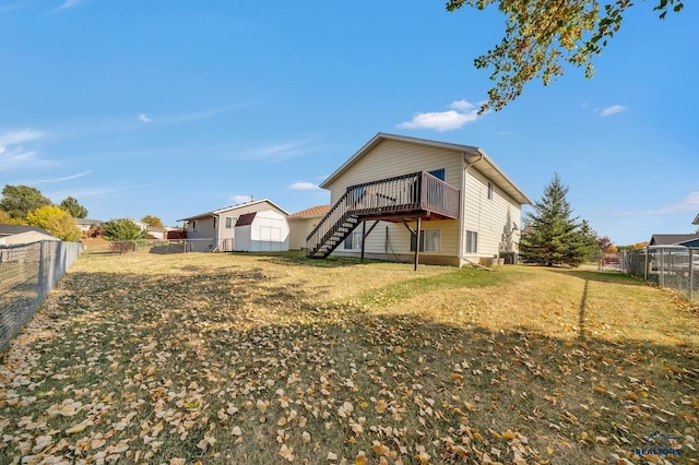 rear view of property featuring a wooden deck and a yard