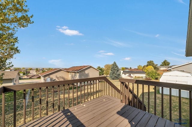 wooden deck with a storage unit and a yard