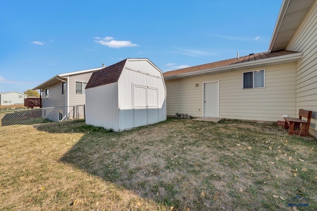 back of property featuring a shed and a lawn