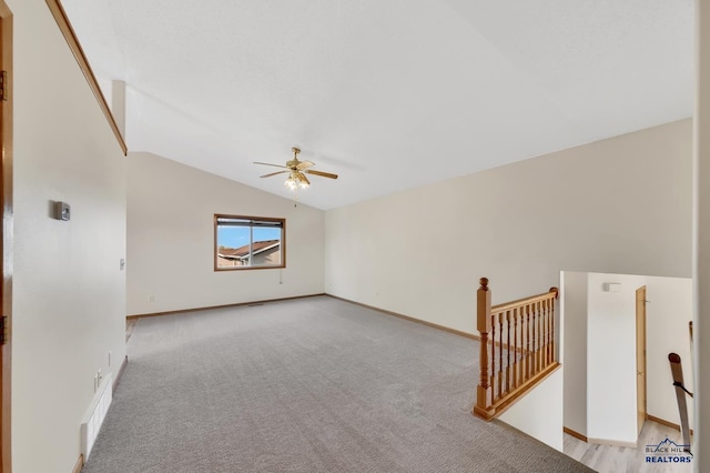 unfurnished room featuring vaulted ceiling, light carpet, and ceiling fan