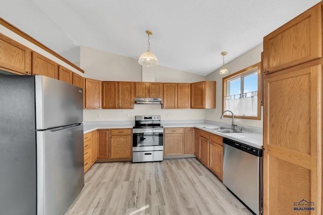 kitchen with lofted ceiling, light hardwood / wood-style flooring, stainless steel appliances, sink, and pendant lighting