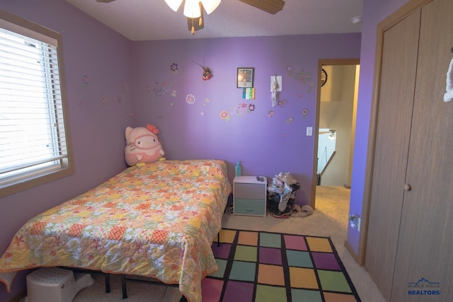 carpeted bedroom featuring a textured ceiling and ceiling fan