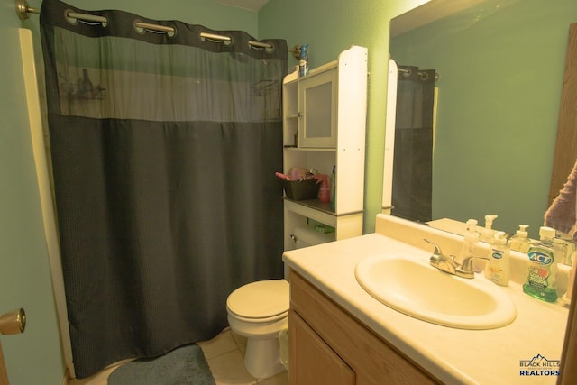 bathroom featuring walk in shower, vanity, toilet, and tile patterned flooring