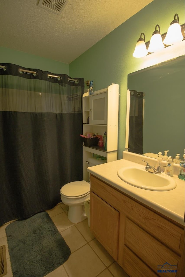 bathroom featuring a textured ceiling, toilet, vanity, a shower with shower curtain, and tile patterned flooring