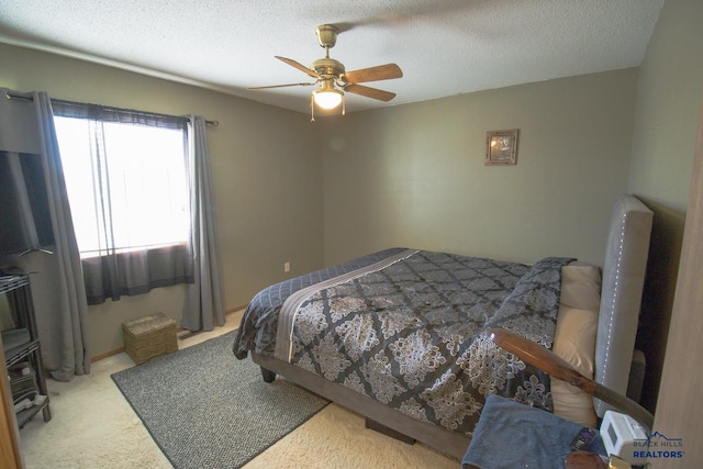 bedroom featuring ceiling fan, a textured ceiling, and light colored carpet