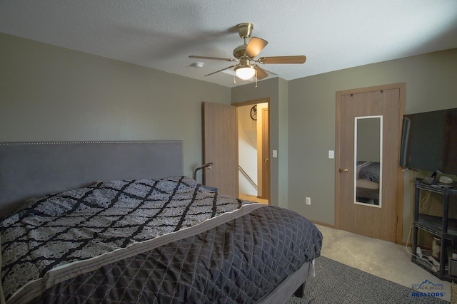 carpeted bedroom featuring a textured ceiling and ceiling fan