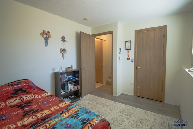 bedroom featuring a closet, wood-type flooring, and a textured ceiling