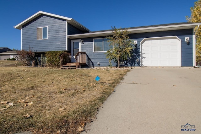 split level home featuring a front lawn and a garage