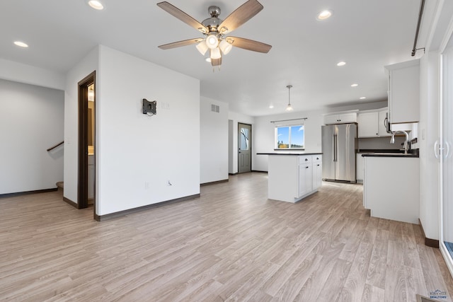 unfurnished living room with ceiling fan and light hardwood / wood-style floors