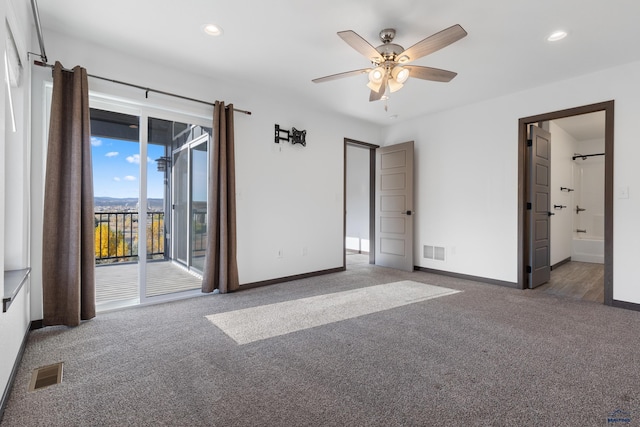 unfurnished bedroom featuring dark colored carpet, ceiling fan, access to exterior, and connected bathroom