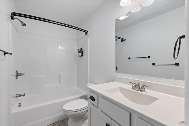 full bathroom with hardwood / wood-style floors, vanity, tub / shower combination, and toilet