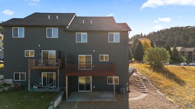 rear view of house featuring cooling unit, a patio area, a yard, and a balcony