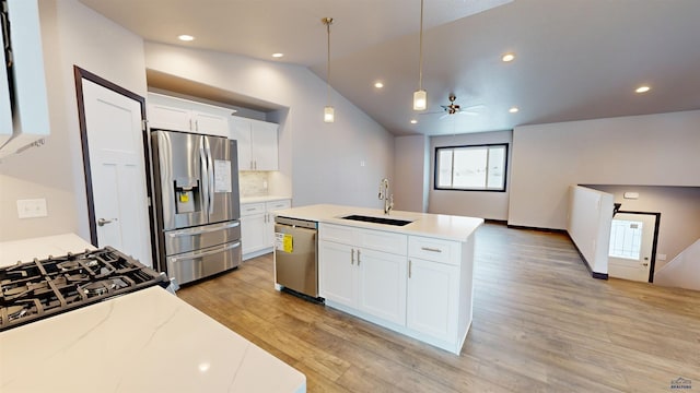 kitchen featuring lofted ceiling, sink, white cabinetry, and stainless steel appliances