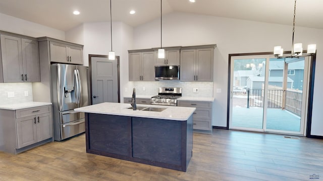 kitchen with backsplash, stainless steel appliances, sink, pendant lighting, and gray cabinets